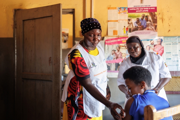 Bukatube Health Center III in Mayuge district, Uganda. - Hadija, a community heanth worker  assists a young lady after administering a contraceptive injection. Community health workers  like Hadija  tend to escort the patients all the way to the health center of referral and help to ease the process of acquiring medication.  The VHTs also participate in post-natal care activities like teaching new moms how to breastfeed.