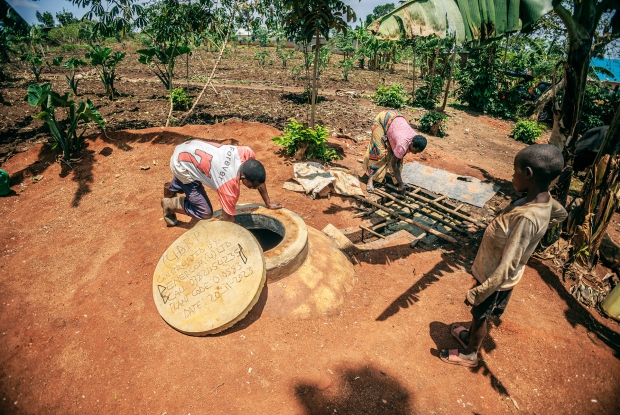 Luwize and her husband Moise  collect bio slurry from their biodigester unit. Biodigesters use cow dung to produce biogas through a process called anaerobic digestion. This process breaks down organic waste in the absence of oxygen to create methane, carbon dioxide, and water.Biogas has many advantages, including being a renewable energy source, reducing pollution, and creating organic fertilizer&copy; CARE / Jjumba Martin 2024.