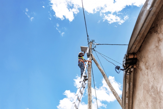May 9th, 2024- Sheder Refugee Camp, Ethiopia. A HumEn technician makes a new house connection in Sheder refugee Camp, northeastern Fafan Zone in the Somali region of Ethiopia. The Ethiopia Petroleum and Energy Authority (PEA) granted the country's first commercial mini-grid license under its new mini-grid directive to Humanitarian Energy (HumEn), an Ethiopian private limited company founded by Mercy Corps, Rensys Engineering and Trading company to provide sustainable energy as a service to refugee and host communities, as well as humanitarian agencies in Ethiopia. The license allows HumEn to deploy and commercially operate a 253 kW solar PV mini-grid to service the refugee and host communities of Sheder town. Ethiopia is home to an estimated 4.7 million forcibly displaced persons, yet only 7% of these people have access to energy. HumEn is committed to finding new ideas and ways to work together to provide clean, long-lasting energy services in the Somali region of Ethiopia and across the country.