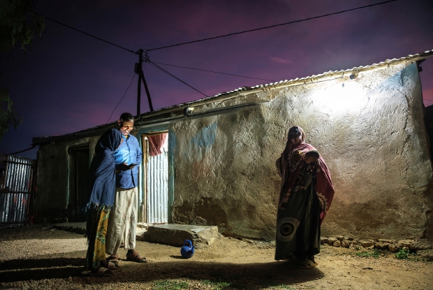 May 12th, 2024- Sheder Refugee Camp, Ali Bahnan using his smartphone with his daughter at their home in Sheder refugee camp, northeastern Fafan Zone in the Somali region of Ethiopia. Until recently, Ali depended on the generator that powered the village for only 2-3 hours every day, which limited his usage of electric devices like mobile phones, as charging them required him to move to the trading center. In 2008, Ali had to flee from Somalia because of the unending Al Shabaab attacks. Choosing to stay home became a risk to his life. The best option, he said, was to cross into Ethiopia and seek aid &ldquo;and we are lucky that when we got here, UNHCR received us well and have since settled here.&rdquo; &ldquo;Right now, I'm staying with my wife and our four children.&rdquo; Ali reflects back on the unbearable period when he had just moved to the Camp. He says that life was complicated and even more unbearable when it was sunny. &ldquo;One couldn't even find a tree to protect oneself from the scorching sun but it is now a lot better. We have trees and there are more structures for shelter.&rdquo; On how he sustains himself and his family, Ali says that as a foreigner it is hard for him to get a job. &ldquo;Finding a source of income is by far the most challenging thing here. It's on and off - sometimes I get (small jobs to do) and other times there is no chance for me to make money.&rdquo; The Mercy Corps' Enter Energy Project in our community is a blessing for both my family and the community. Before the introduction of the project, I was paying a lot of money to just get light for 2-3 hours at night. Community-wise, it was risky to move at night. There were numerous snake bite cases and security issues but we are now more secure and confident at night because the constant light source makes it easy for us to see what we couldn't see in the dark, back then. Some people have even extended their work hours into the night.