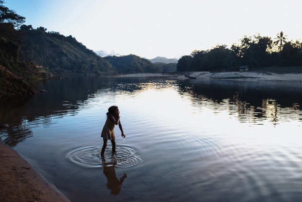 31/10/2023 Sambava, Madagascar. A young girl washes herself by the river. Here, washing in the river has historically been a common practice. For me, Madagascar will always be at heart. Those evenings by the river and how the sun kissed it&hellip; felt like nature was bragging.