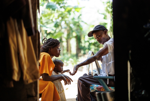 24-year-old Sandra intently listens to family planning advice from Kiriibwa Ronald, the Community Health Worker in her community. - Ronald conducts daily home visits to his community to implement various programs that focus on maternal and child health. Community Health Workers like him also advise women on the family planning options to help them make informed decisions and even provide short-term methods like pills and condoms within their community, making them more accessible.