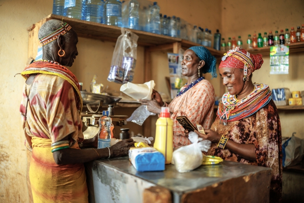 13/03/2025 Marsabit county, Kenya. Galmisan with her business associates, Natodowa attending to their shop. Under the Kuza Jamii Project, the group was mentored on business skills under the Gender Action Learning Systems (Gals), which aimed to make them believe that they could change their situation. Together, they took a loan from their VSLA to start a retail shop business they were able to repay the money.  Galmisan further took a personal loan to purchase her first camel, which is currently pregnant.